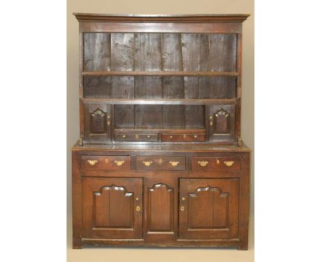 A GEORGIAN OAK DRESSER, mid 18th century, the boarded delft rack with moulded cornice over three shelves, the lower shelf wit