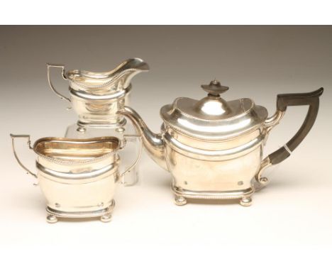 A BACHELOR'S EDWARDIAN THREE PIECE SILVER TEA SERVICE, maker Thomas Bradbury, Sheffield 1902 (teapot) and 1903, of rounded fl