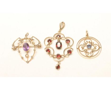 THREE EDWARDIAN 9CT GOLD WIREWORK PENDANTS, one of scroll cartouche form set with garnets, one circular centred by a sapphire