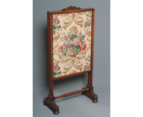 A WILLIAM IV MAHOGANY FRAMED FIRESCREEN of oblong form with two sliding panels now with a floral linen covering, scrolled car