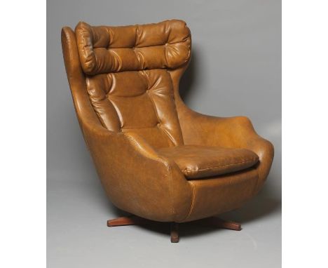 A PARKER KNOLL STATESMAN AMBASSADOR SWIVEL ARMCHAIR, Model 1028, button upholstered in brown faux leather, on teak foot, manu