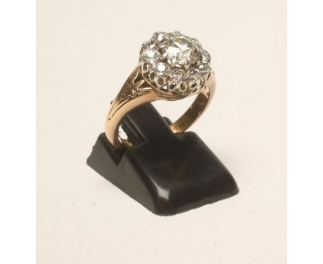 A DIAMOND CLUSTER RING, the central old cut stone of approximately 0.5cts claw set to a border of ten similar smaller stones 