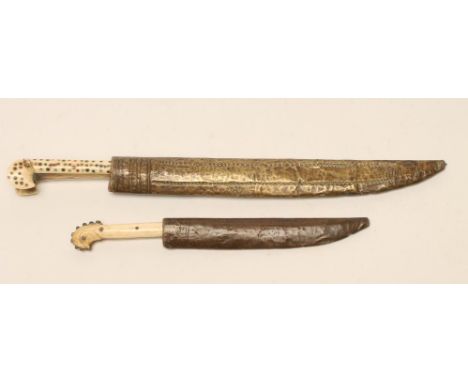 A BALKAN DAGGER, late 19th century, with 9 3/4" curved blade, brass hilt of typical form with two piece bone grips inset with