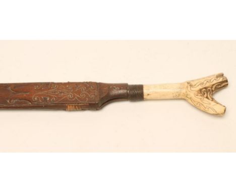 A DAYAK HEAD HUNTER'S SWORD, late 19th century, with 14 1/2" shaped and brass inlaid blade, carved bone hilt with woven colla