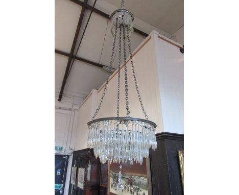 A GILT METAL AND DROP LUSTRE CHANDELIER of graduated tiered circular form, suspended by chains from a similar corona, 15" x 3