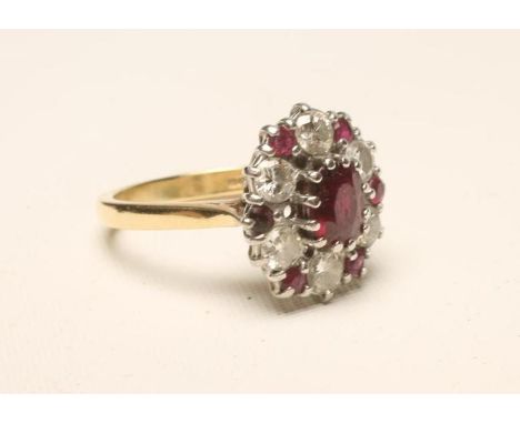 A RUBY AND DIAMOND CLUSTER RING, the central oval facet cut ruby claw set to a border of six round brilliant cut diamonds wit