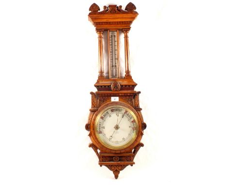 An aneroid barometer in carved oak case, signed B.Mallinson & Co, Huddersfield