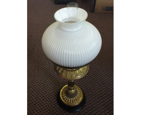 A brass oil lamp with white shade