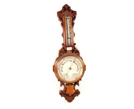 An aneroid barometer in carved oak case (name rubbed)