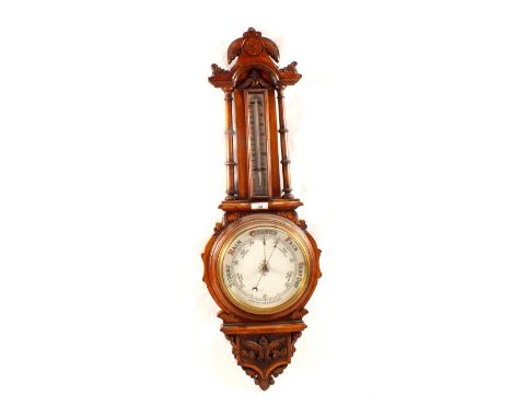 An aneroid barometer in carved oak case