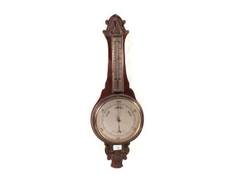 An aneroid barometer in carved oak case