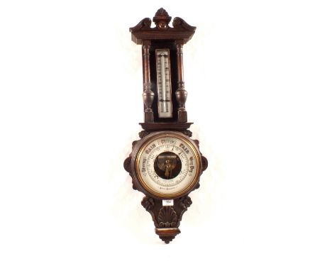 An aneroid barometer in floral and shell carved oak case, signed Aitchison & Co, Optician to HM Gov, London and provinces