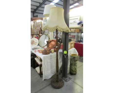 A dark wood floor standing lamp with shade.