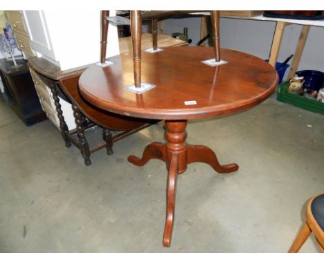 A dark pine round kitchen table on centre column tripod base height 76cm, diameter 91cm