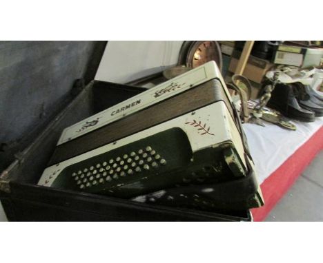 A cased Carmen piano accordion.