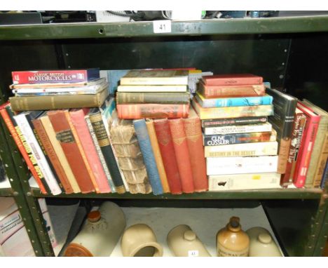 A shelf full of books on many subjects (annuals, novels &amp; natural history)