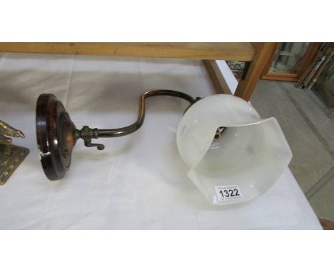 A Victorian brass gas swan neck wall light with glass shade.