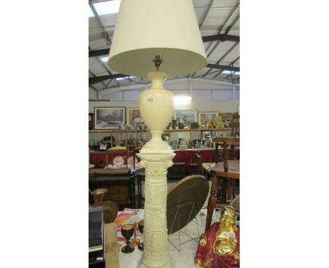 A cream pottery table lamp with shade on a plaster pillar, lamp needs rewiring, (pillar 64.5 cm and has some chips) This item