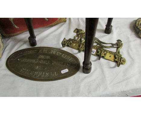 A brass engine plate and a set of brass hooks.