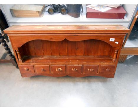 A stained pine kitchen wall shelf unit with drawers, height 57cm at tallest point, width 102cm