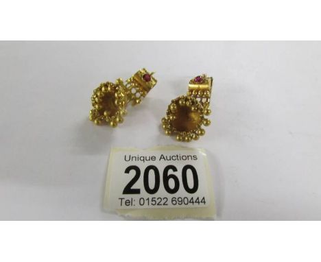 A pair of pendant earrings set ruby coloured stones, (test as 18ct gold).