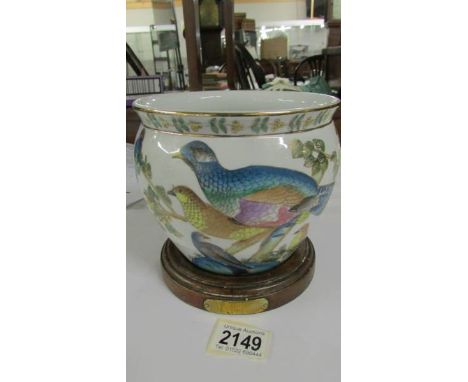A teak pot stand made from teak from HMS Terrible and an oriental style planter decorated with birds.