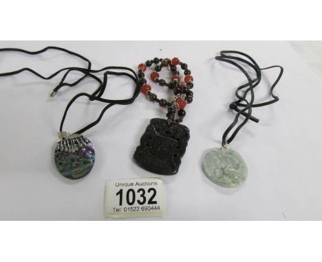 A Chinese necklace/pendant with silver mounts, a paua shell pendant with silver mounts and jade pendant,.