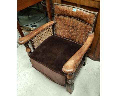 An early Ercol low seat armchair with woven + embossed leather back, cane sides &amp; square legs, with original Ercol label 