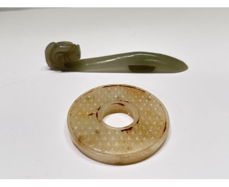 A Chinese carved hardstone jade coloured belt buckle and a carved hardstone circle.  In good condition.WE TAKE GREAT CARE in 