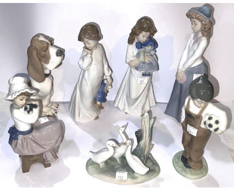 7 Nao figurines: boy holding a football, girl holding a dog, 2 girls holding dolls, another girl and 2 animal figurines 