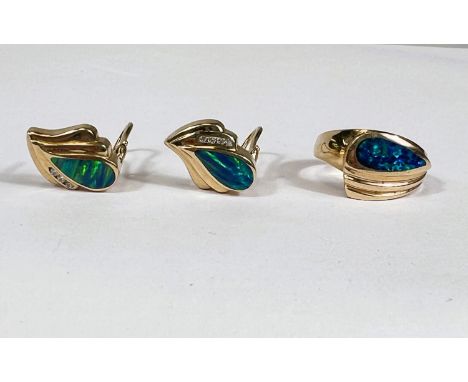 A yellow metal dress ring with broad ribbed top, inset elongated dark blue opal type stone; a pair of matching earrings, all 