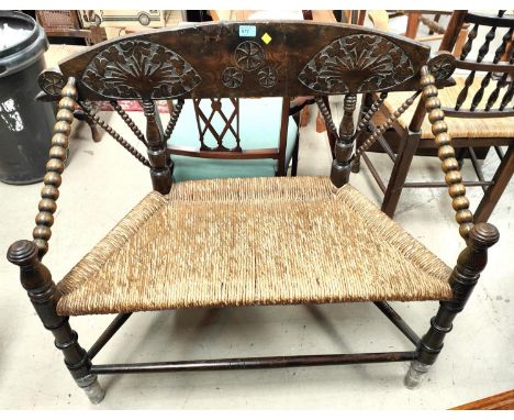 An unusual late 19th/early 20th century turners 2 seater settee with carved back, extensive bobbin turning and rush seat 