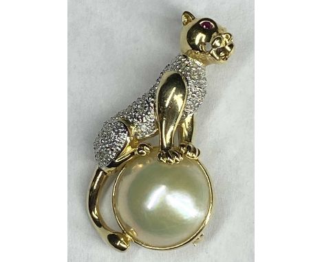 14CT GOLD PANTHER SURMOUNTING A HALF PEARL BROOCH - having 10 small diamonds to an illusion set body with ruby red eyes, 8.5g