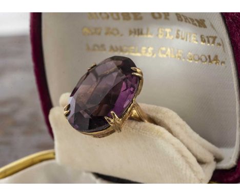 A 9ct gold gem set dress ring, the oval mauve coloured gem in a four claw setting, on a 9ct gold hallmarked shank, ring size 