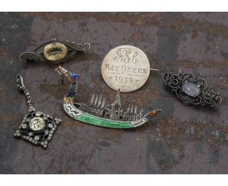 A collection of jewels, including a silver and enamel Siam boat brooch, a paste set pendant, two gem set brooches, and a May 