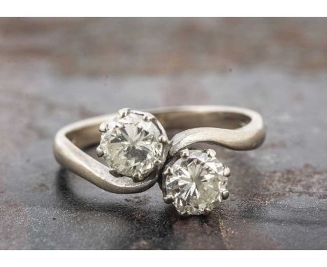 An 18ct gold diamond crossover dress ring, the brilliant cuts in claw setting, ring size L, on a white gold hallmarked shank,