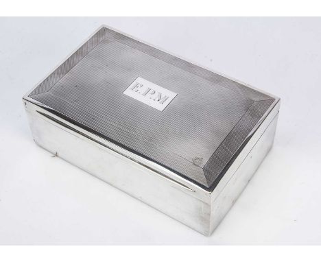 A large 1960s silver desk or table cigarette box, 23cm wide, with engine turned decoration to lid and engraved initials E.P.M