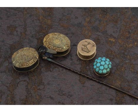 A 19th Century turquoise and gold dress stud, together with another carved with family crest of armoured arm and axe protrudi