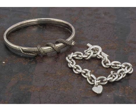 A contemporary white metal hinged bangle, with serpent decoration, 6cm x 5cm together with an oval linked silver bracelet wit