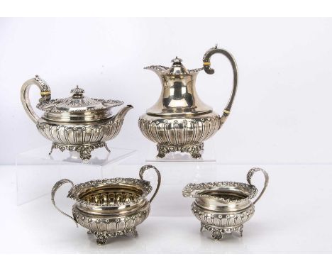 An early George V silver four piece tea set retailed through West & Sons of Dublin, squat form with floral flared rim and aca