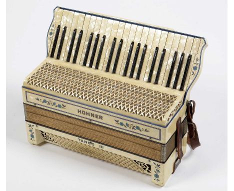 A Hohner Tango III 120 bass piano accordion, in cream pearloid casing, wooden case.