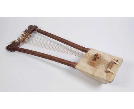 A Begena Ethiopian bass lyre harp, with double carved uprights, fitted with ten strings, square soundbox, spare string and in