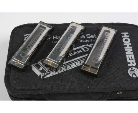 A set of seven Hohner Bluesband harmonicas, in fitted fabric case.