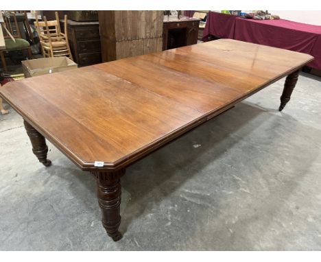 A late Victorian walnut dining table, raised on turned legs with brass caps and ceramic castors. Extends to 120' with three e