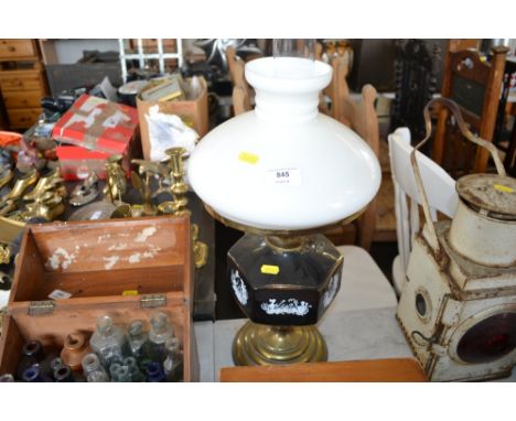 An oil lamp with a milk glass shade