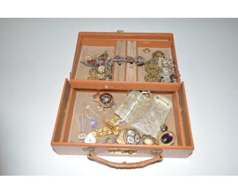 A brown leather jewellery box containing costume jewellery with opal type bracelet