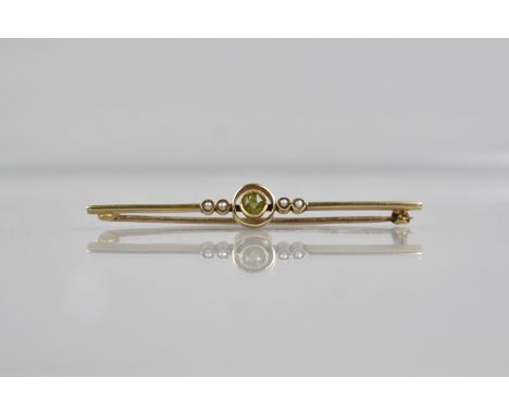 A 15ct Gold, Peridot and Seed Pearl Bar Brooch, Central Oval Cut Stone 4.1mm Diameter, Bezel Set and Flanked by Two Pairs of 