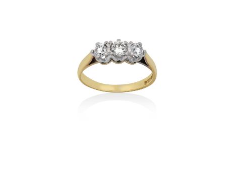 An 18 Carat Gold Diamond Three Stone Ringthe round brilliant cut diamonds in white claw settings, to a yellow tapered shoulde