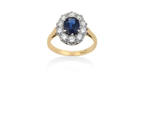 A Sapphire and Diamond Cluster Ringthe oval cut sapphire within a border of round brilliant cut diamonds, in white claw setti