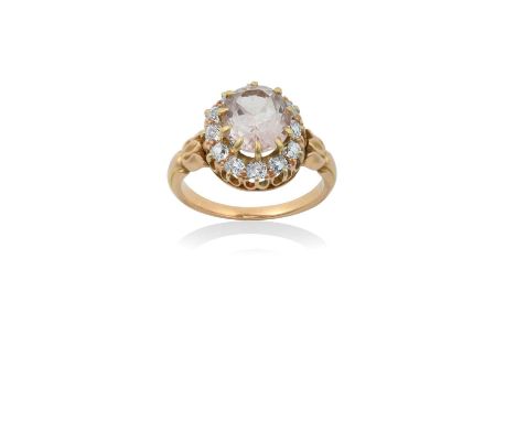 A Topaz and Diamond Ringthe oval cut light pink topaz within a border of old cut diamonds, in yellow claw settings, to a fanc